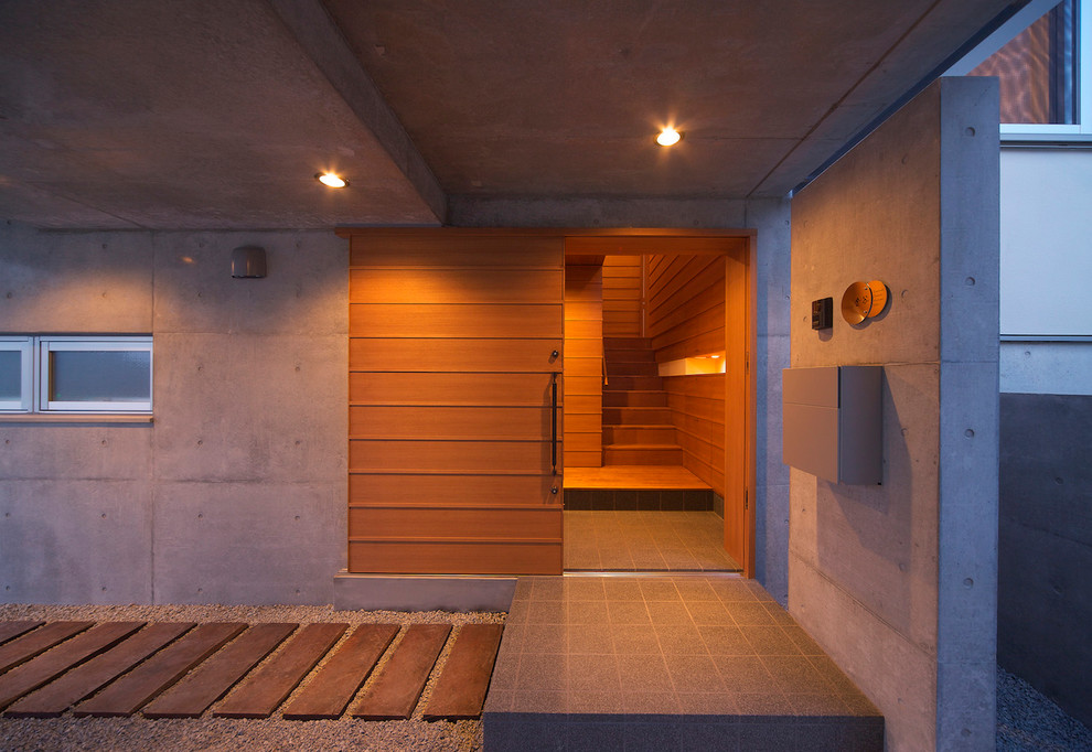 Réalisation d'une porte d'entrée minimaliste avec une porte en bois brun et une porte coulissante.