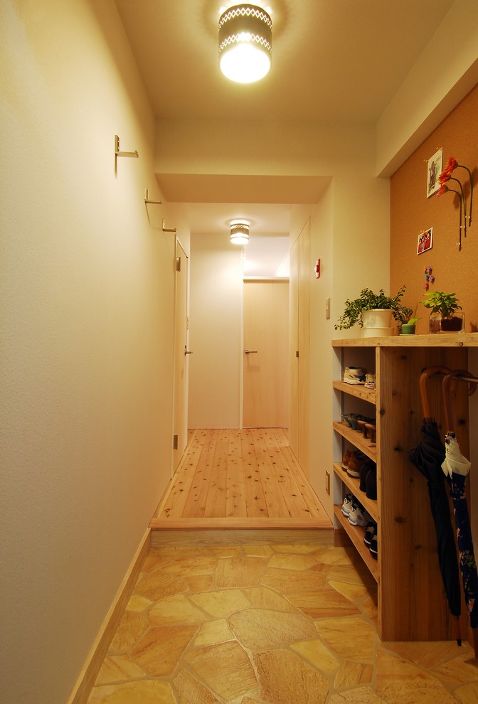 Aménagement d'une petite entrée contemporaine avec un couloir, un mur blanc, un sol en vinyl, une porte simple, une porte blanche et un sol beige.