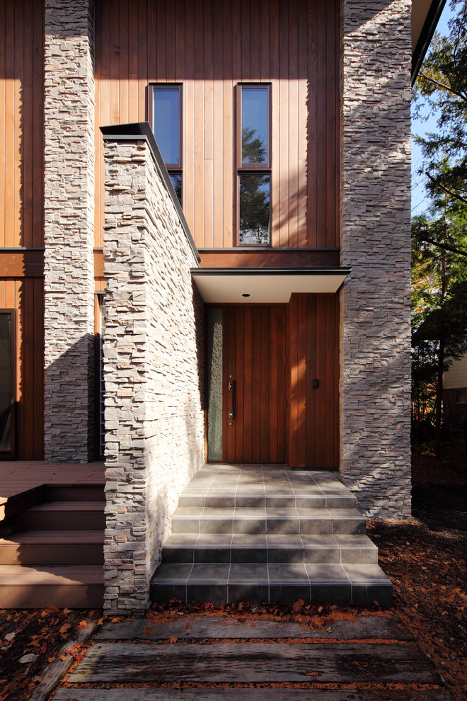 Exemple d'une petite porte d'entrée moderne avec un mur marron, un sol en carrelage de céramique, une porte simple, une porte en bois foncé et un sol gris.