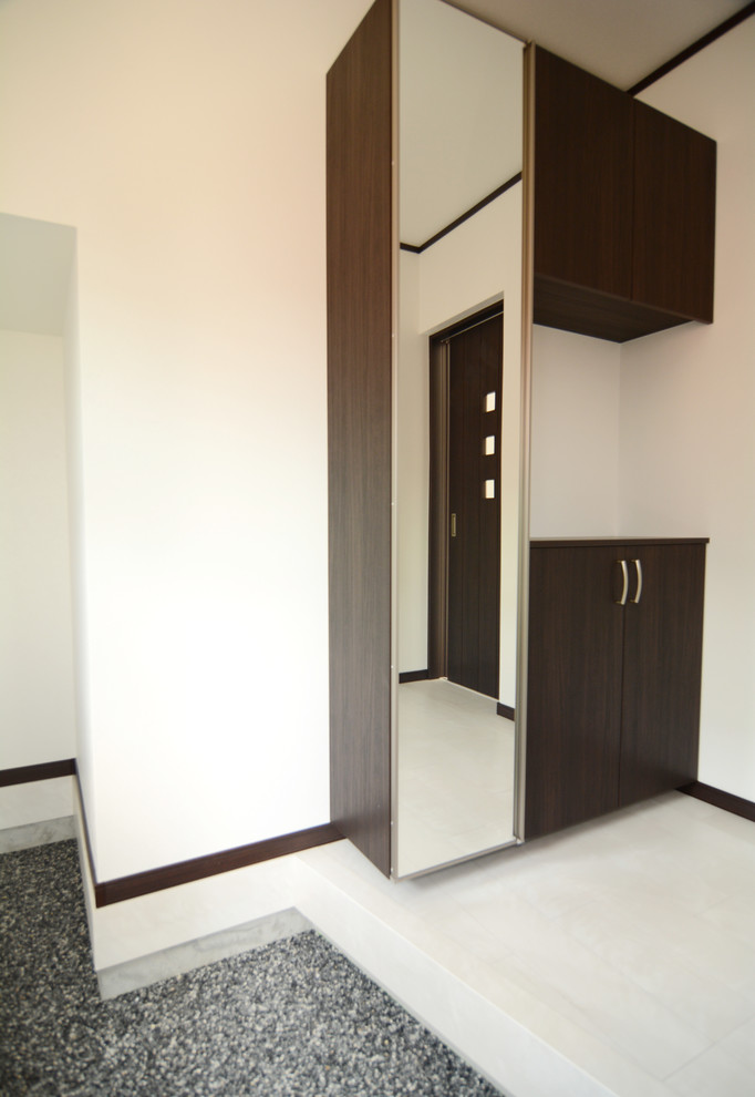 Moderner Eingang mit Korridor, weißer Wandfarbe, Sperrholzboden, dunkler Holzhaustür und weißem Boden in Sonstige