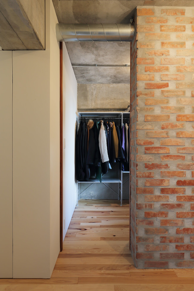 Ejemplo de hall urbano pequeño con paredes grises, suelo de madera en tonos medios, puerta simple, puerta blanca y suelo marrón