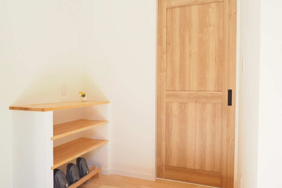 Immagine di un piccolo corridoio minimalista con pareti bianche, parquet chiaro, una porta scorrevole, una porta in legno chiaro, pavimento grigio, soffitto in carta da parati e carta da parati