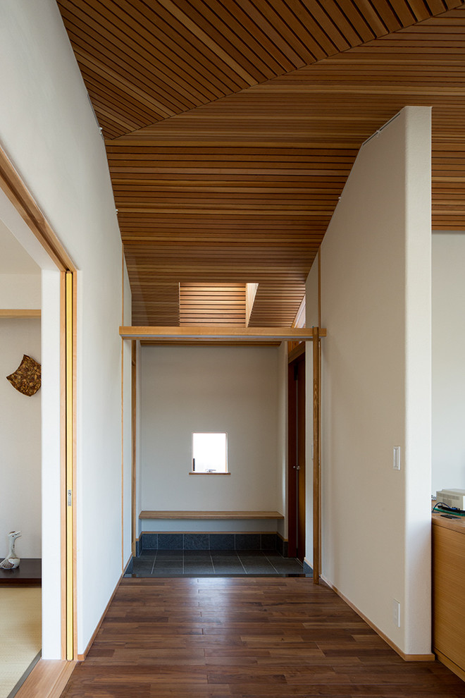 Mittelgroße Asiatische Haustür mit beiger Wandfarbe, Porzellan-Bodenfliesen, Einzeltür, hellbrauner Holzhaustür und schwarzem Boden in Sonstige
