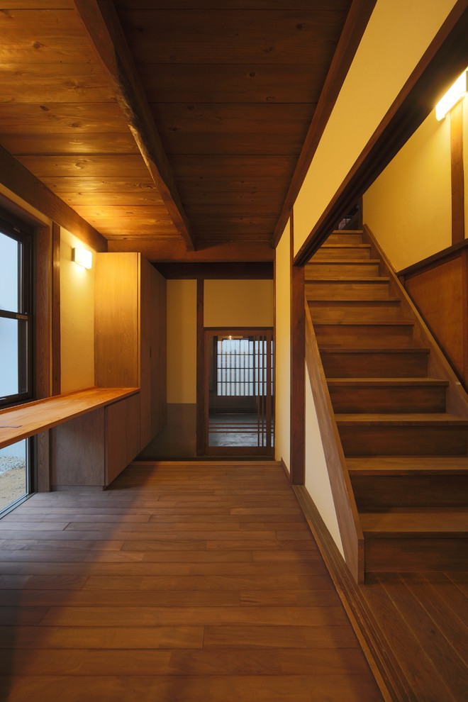 Imagen de puerta principal asiática grande con paredes blancas, suelo de madera en tonos medios, puerta corredera, puerta de madera en tonos medios y suelo marrón