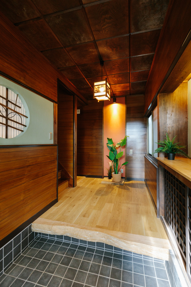 World-inspired entrance in Other with green walls, medium hardwood flooring, beige floors and a brown front door.