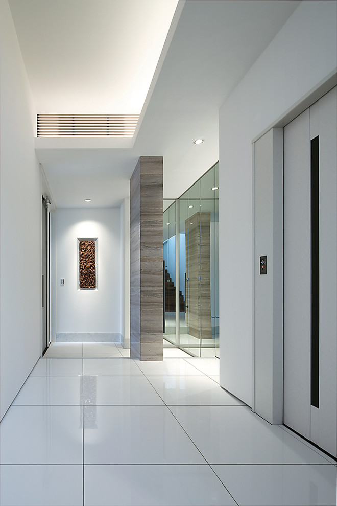 Inspiration pour une entrée design avec un couloir, un mur blanc et un sol en carrelage de céramique.