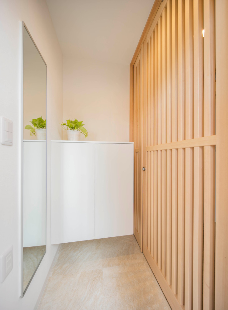 Idee per un piccolo corridoio scandinavo con pareti bianche, pavimento in cemento, una porta singola, una porta in legno chiaro e pavimento grigio