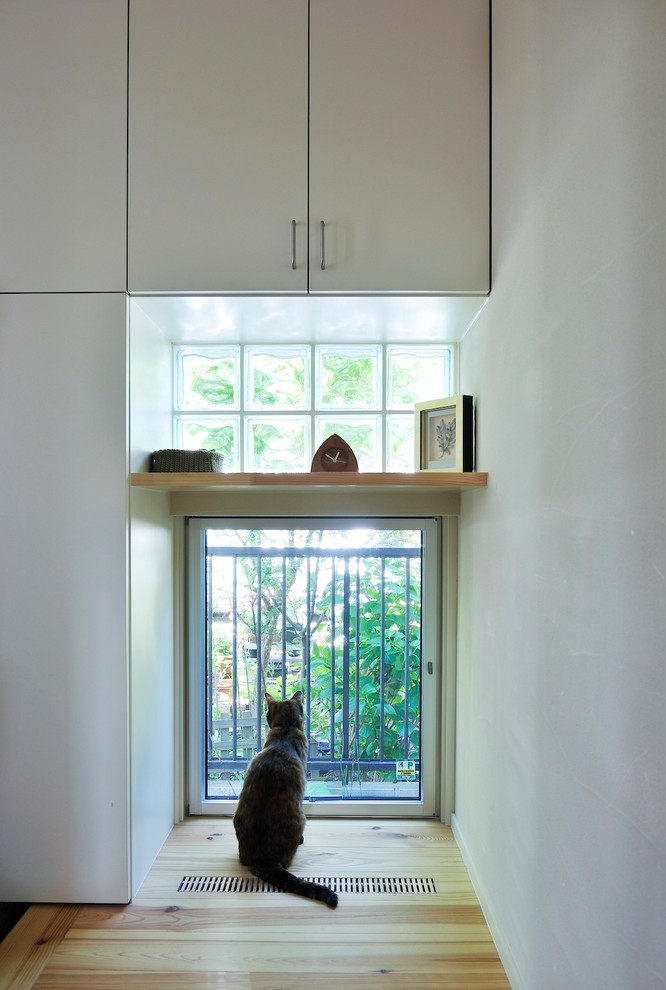 Пример оригинального дизайна: прихожая в скандинавском стиле с белыми стенами, деревянным полом, одностворчатой входной дверью, входной дверью из светлого дерева и бежевым полом