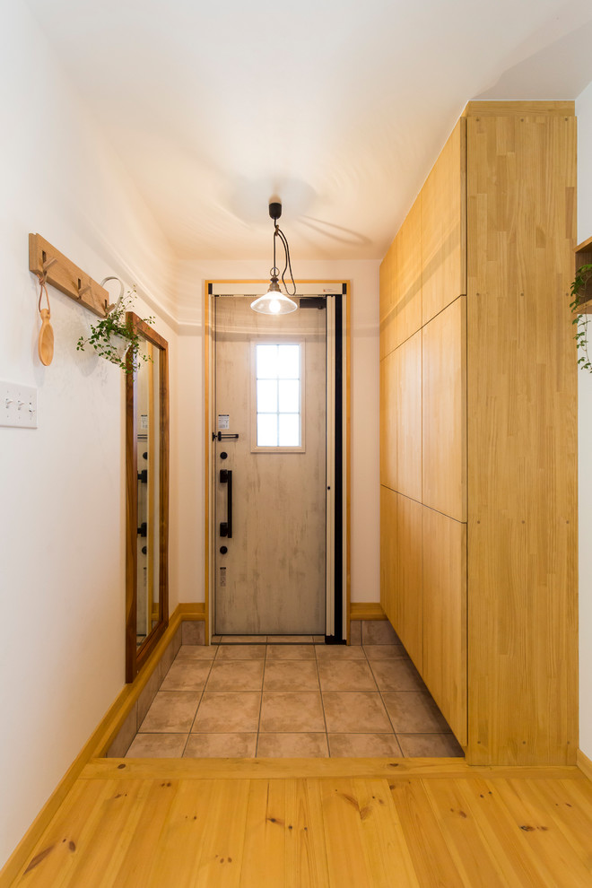 Uriger Eingang mit weißer Wandfarbe, Einzeltür, weißer Haustür und grauem Boden in Sonstige