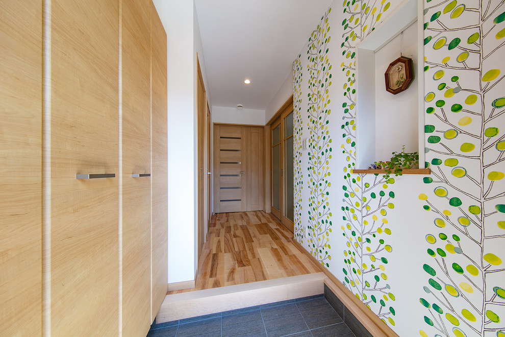 Idee per un ingresso o corridoio minimalista con pareti bianche, pavimento grigio e armadio