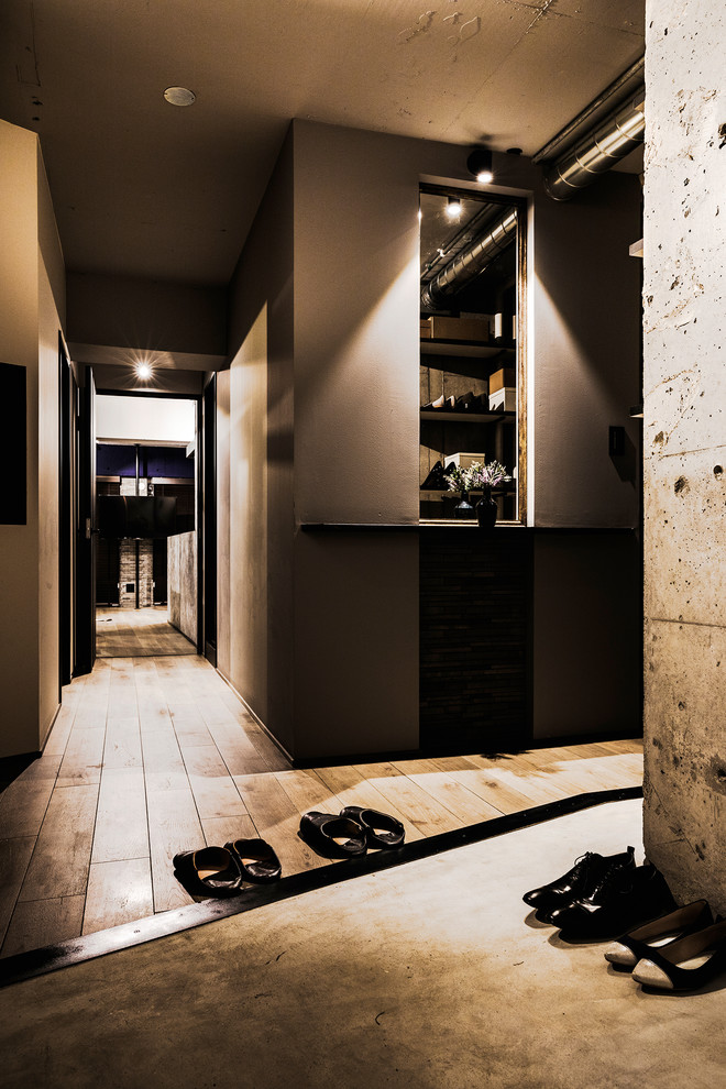 インダストリアルスタイルのおしゃれな玄関 (グレーの壁、コンクリートの床、グレーの床) の写真