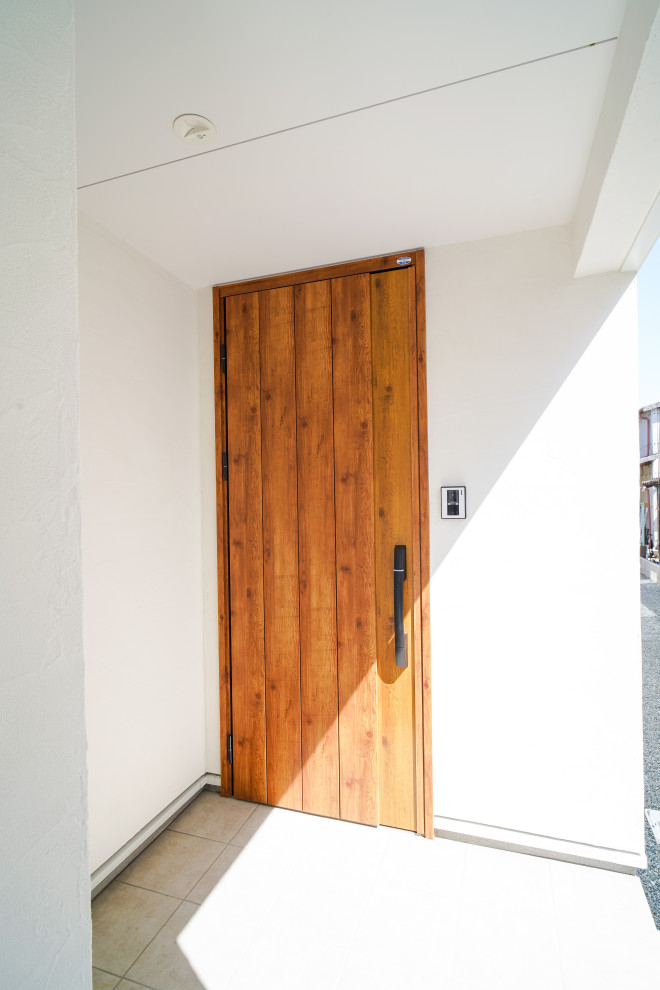 Ispirazione per una porta d'ingresso minimalista di medie dimensioni con pareti bianche, pavimento in terracotta, una porta singola, una porta in legno bruno e pavimento beige