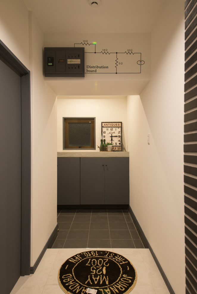 Industrial Eingang mit Korridor, weißer Wandfarbe, Porzellan-Bodenfliesen und schwarzem Boden in Sonstige