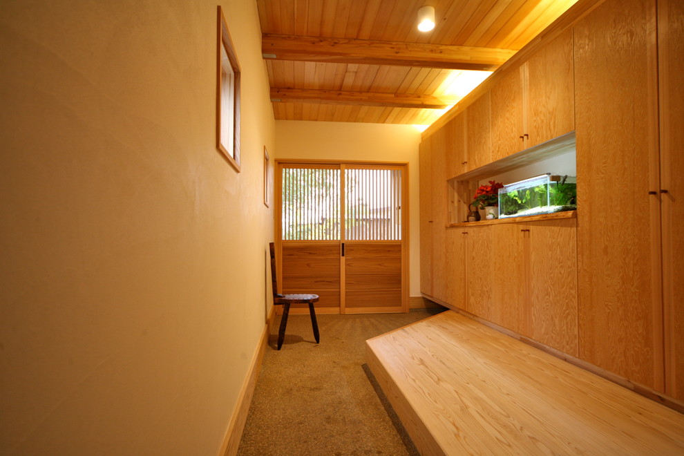Источник вдохновения для домашнего уюта: узкая прихожая среднего размера в восточном стиле с белыми стенами, раздвижной входной дверью, входной дверью из светлого дерева и серым полом