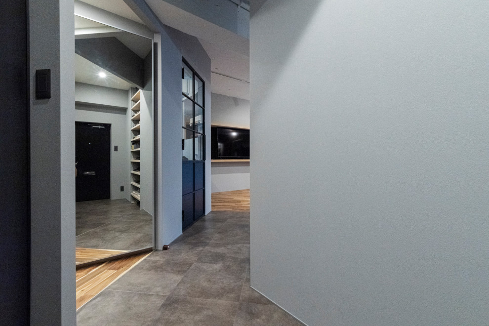 Modelo de hall industrial de tamaño medio con paredes grises, puerta simple, puerta negra y suelo gris