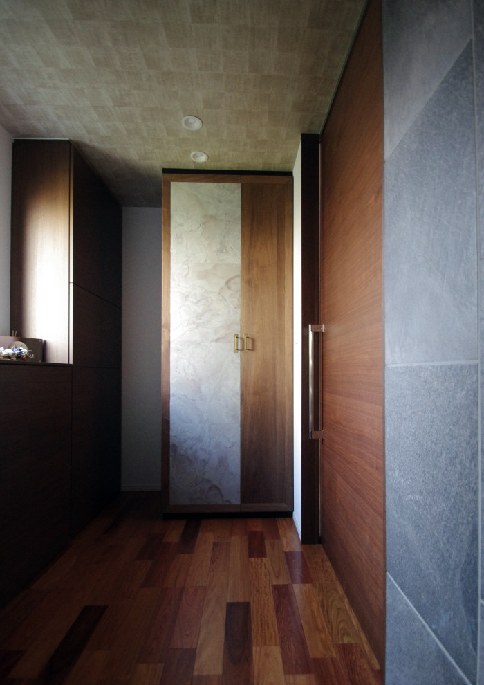 Immagine di un ingresso o corridoio minimalista con pareti grigie e pavimento marrone