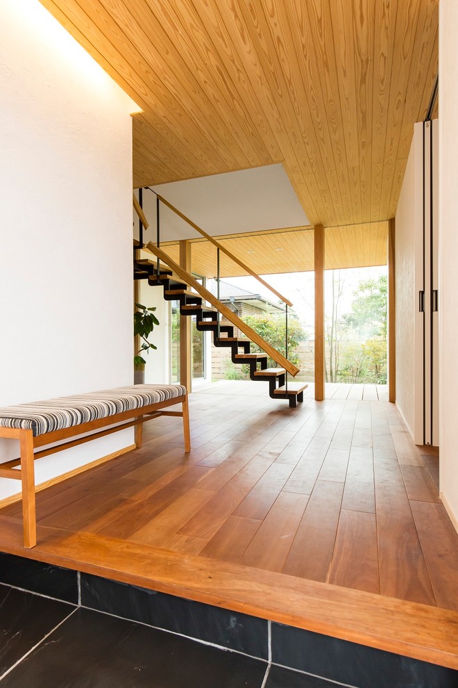 Ejemplo de hall de estilo zen con paredes blancas y suelo de madera en tonos medios