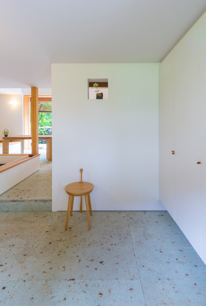 Inspiration pour une petite entrée minimaliste avec un couloir, un mur marron, une porte simple, une porte en bois brun et un sol blanc.
