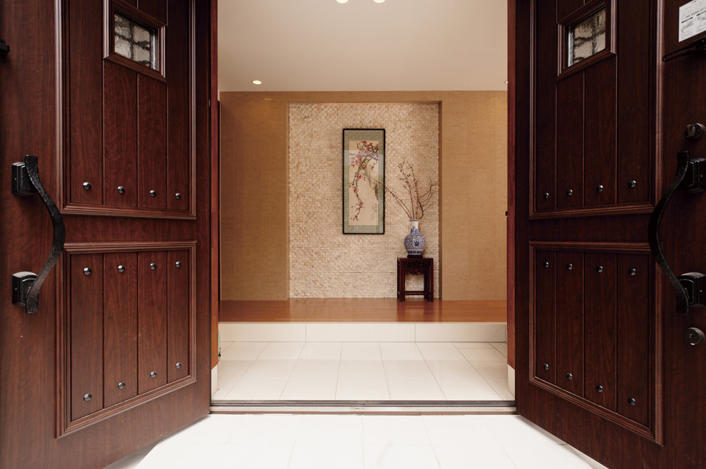 Idée de décoration pour une entrée asiatique avec un sol en marbre et une porte double.