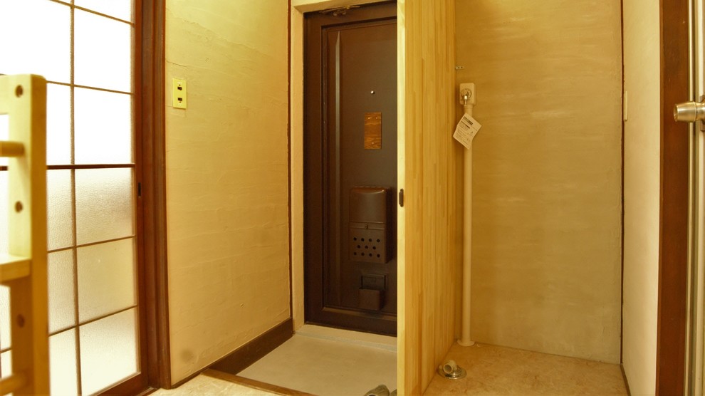 他の地域にある低価格の小さな和風のおしゃれな玄関ホール (白い壁、クッションフロア、茶色いドア、ベージュの床) の写真