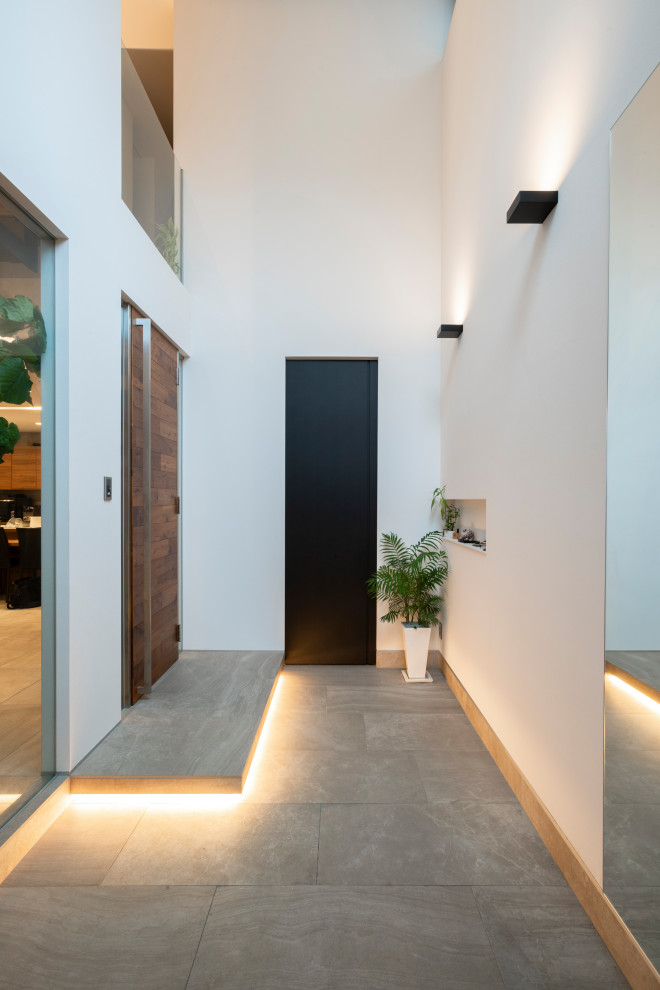Ispirazione per un corridoio moderno con pareti bianche, pavimento in gres porcellanato, una porta singola, una porta in legno bruno, soffitto in carta da parati e carta da parati