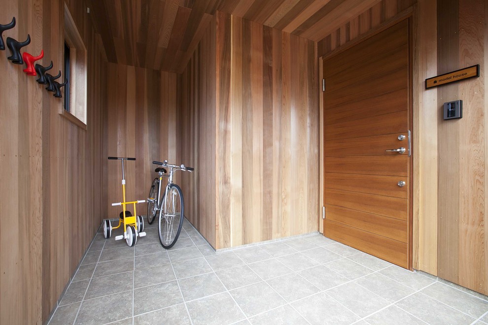 Cette photo montre un petit hall d'entrée tendance avec un sol en carrelage de porcelaine et une porte simple.
