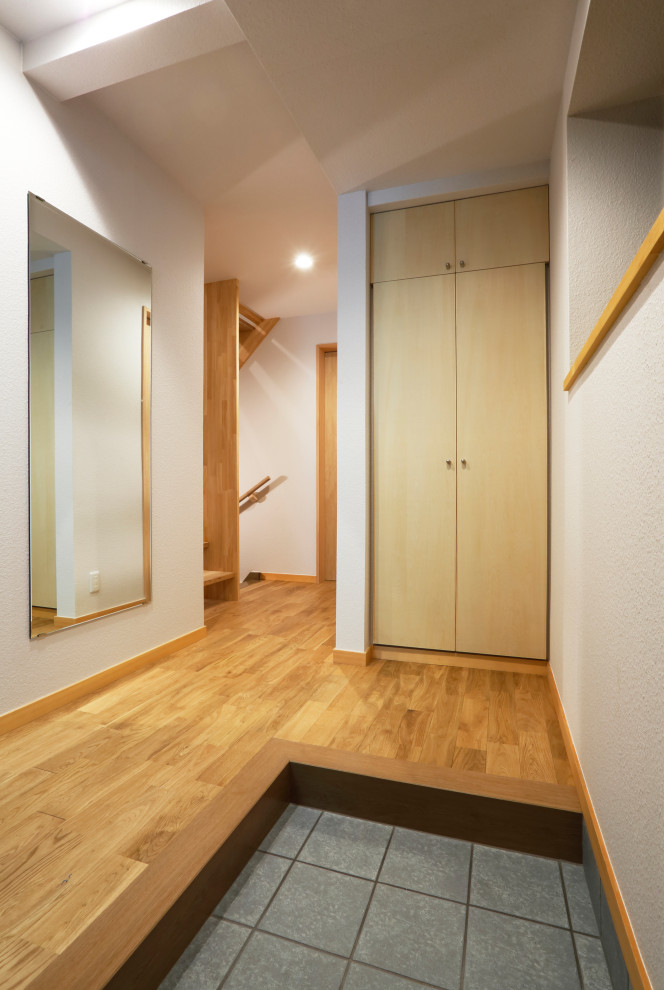Foto di un piccolo corridoio moderno con pareti bianche, parquet chiaro, una porta singola, una porta blu, soffitto in carta da parati e carta da parati