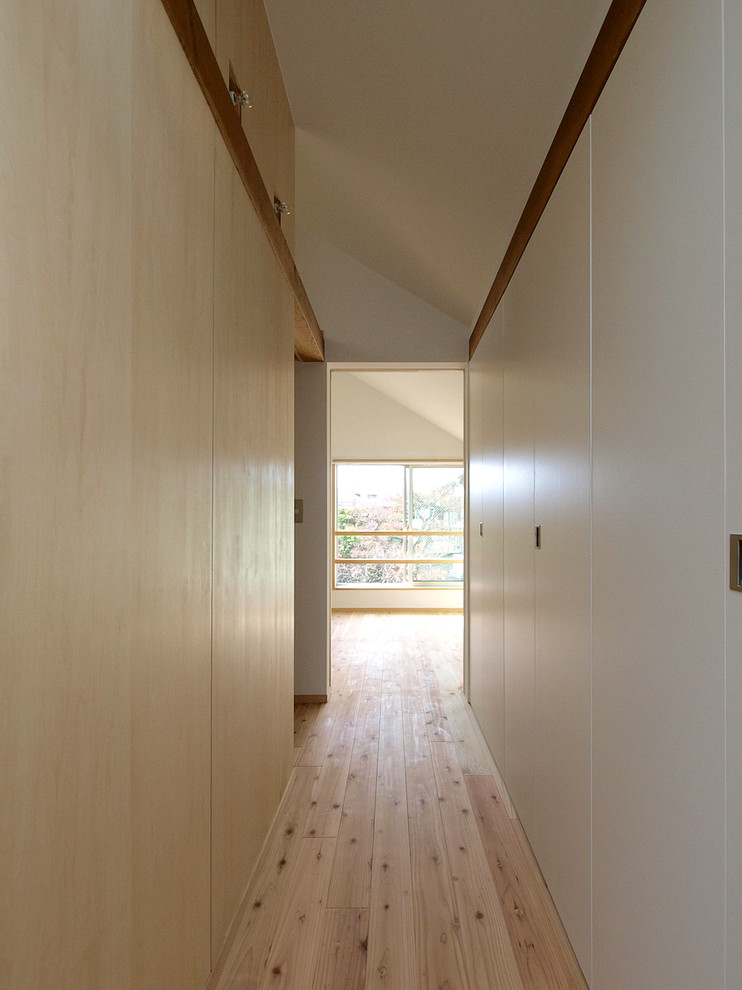 Scandi entrance in Tokyo with white walls, light hardwood flooring and beige floors.