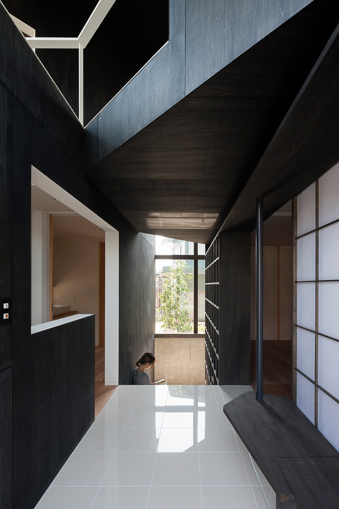 横浜にあるミッドセンチュリースタイルのおしゃれな玄関 (黒い壁、磁器タイルの床、白い床) の写真