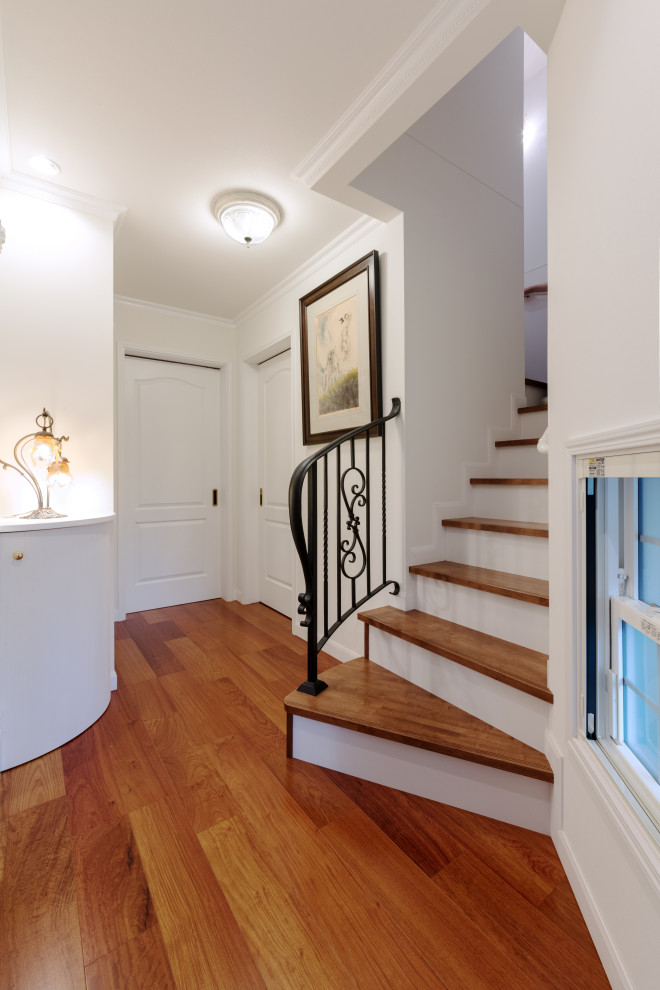 Kleines Klassisches Foyer mit weißer Wandfarbe, Sperrholzboden und braunem Boden in Sonstige