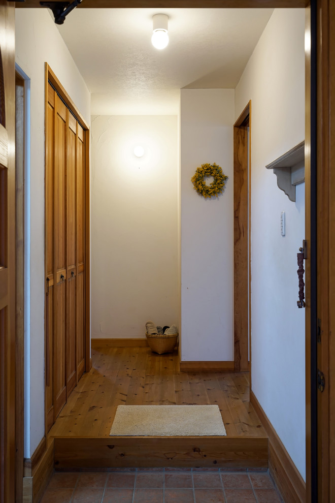 Scandi hallway in Other with white walls, terracotta flooring, a single front door, a medium wood front door and brown floors.