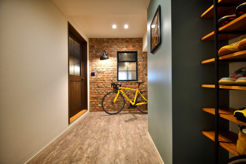 Réalisation d'une entrée urbaine de taille moyenne avec un couloir, un mur multicolore, une porte simple, une porte en bois brun et un sol gris.