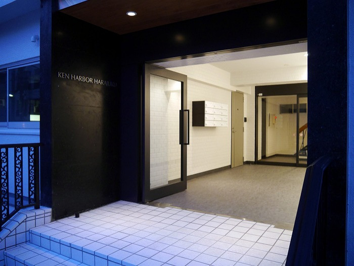 東京23区にある中くらいなモダンスタイルのおしゃれな玄関 (白い壁、黒いドア) の写真