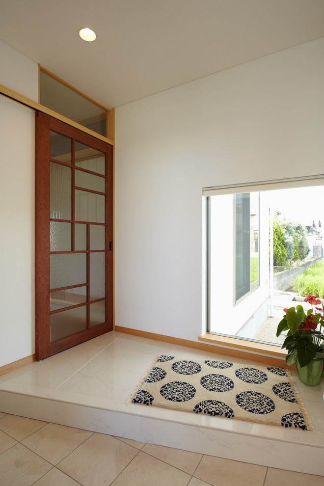 他の地域にあるアジアンスタイルのおしゃれな玄関 (白い壁、ベージュの床) の写真
