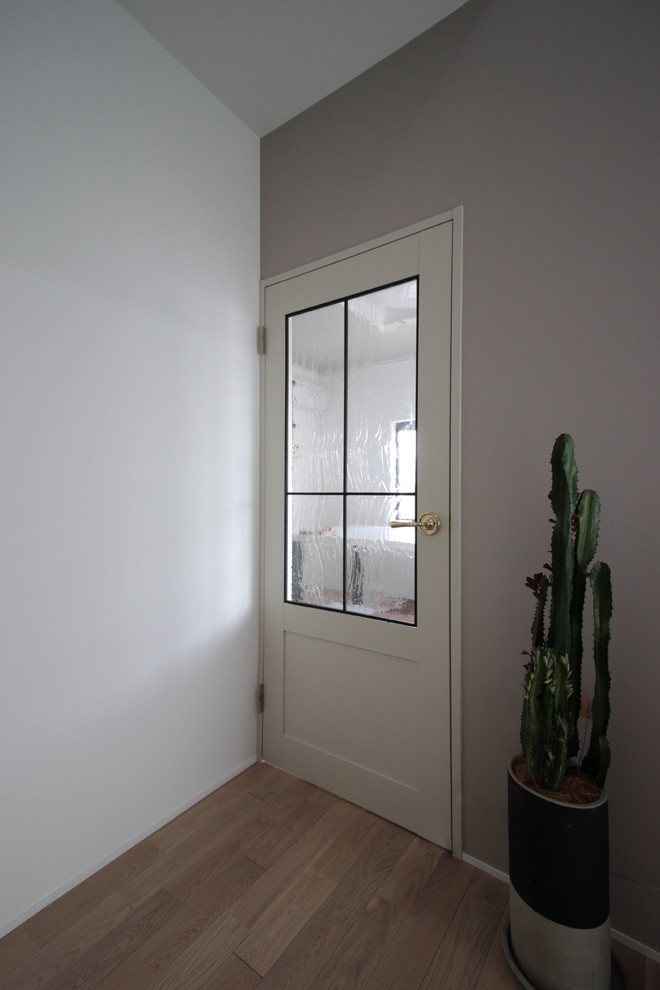 他の地域にあるお手頃価格の小さなシャビーシック調のおしゃれな玄関 (グレーの壁、淡色無垢フローリング、白い床) の写真