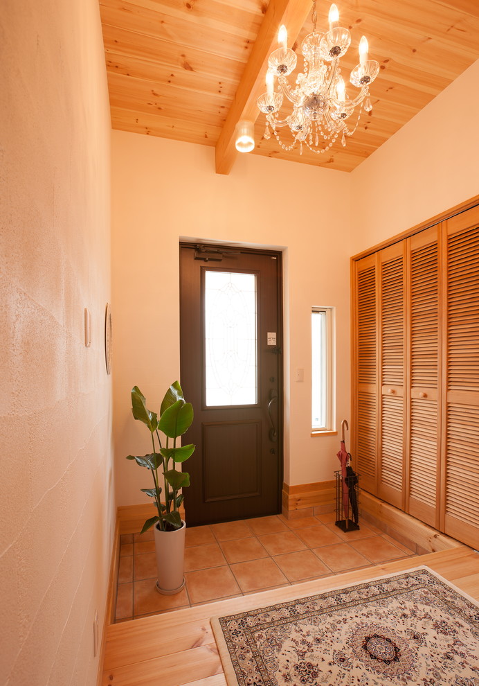 Modelo de hall de estilo zen con paredes blancas, suelo de baldosas de terracota, puerta simple, puerta negra y suelo naranja