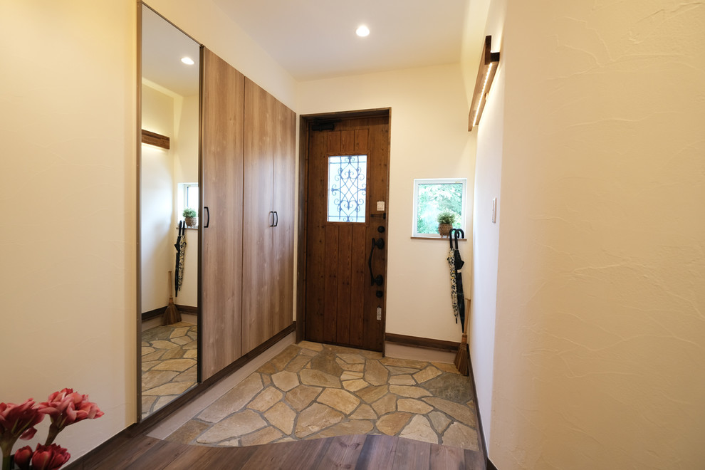 福岡にあるアジアンスタイルのおしゃれな玄関 (白い壁、濃色無垢フローリング、木目調のドア) の写真
