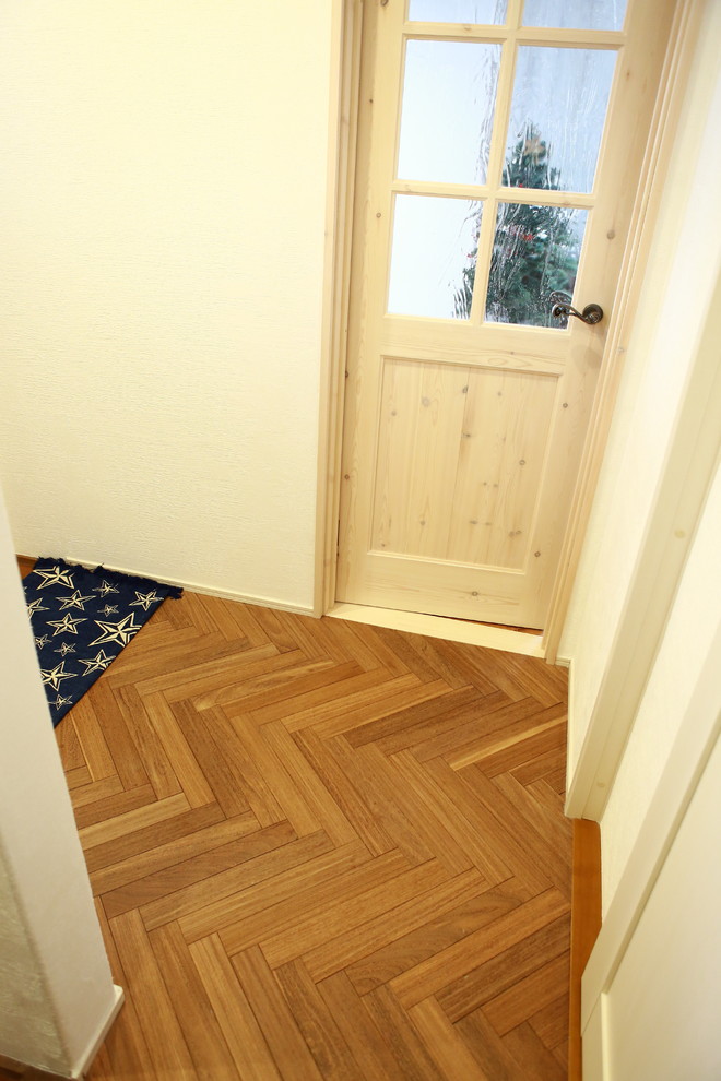 Foto di un ingresso o corridoio country con una porta singola e una porta in legno chiaro