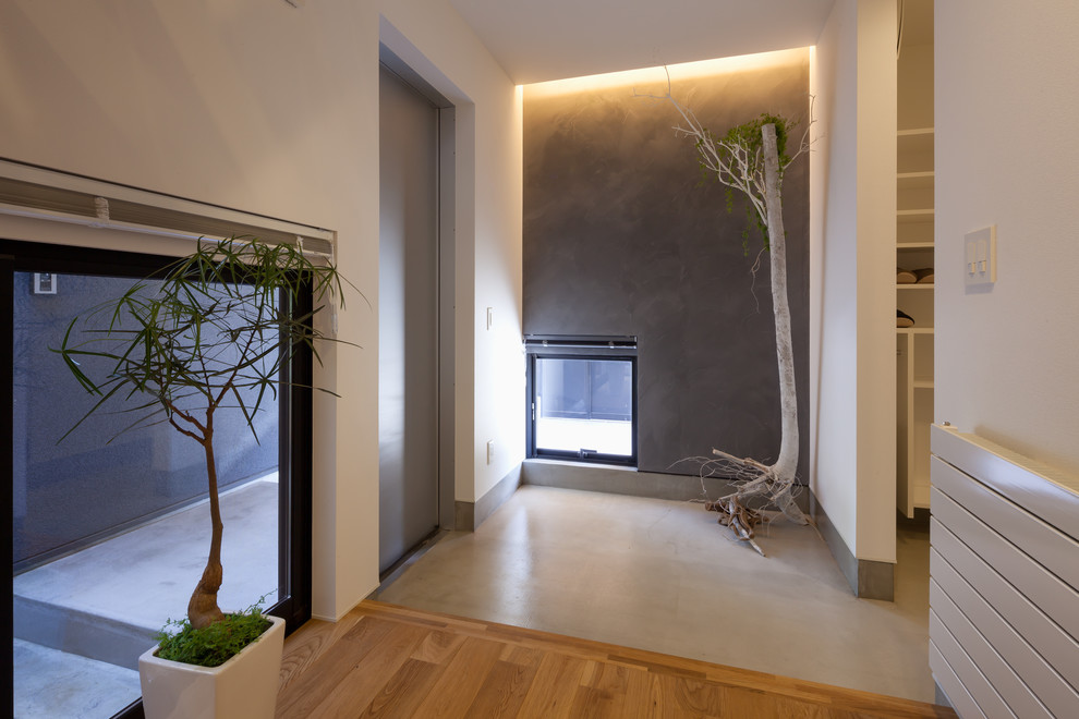 Inspiration pour une entrée design avec un couloir, un mur multicolore, sol en béton ciré, une porte simple, une porte métallisée et un sol gris.