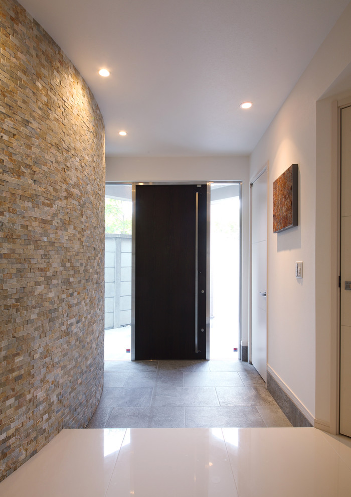 На фото: узкая прихожая среднего размера в стиле модернизм с белыми стенами, полом из керамической плитки, одностворчатой входной дверью, коричневой входной дверью и белым полом
