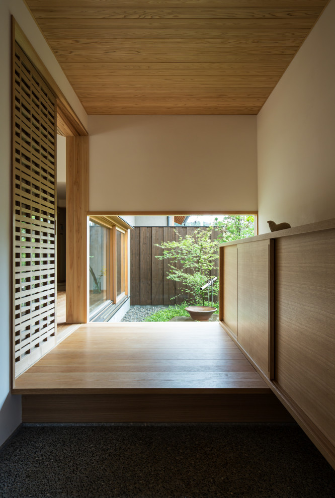Diseño de hall de estilo zen con paredes blancas, suelo de madera en tonos medios, madera y papel pintado
