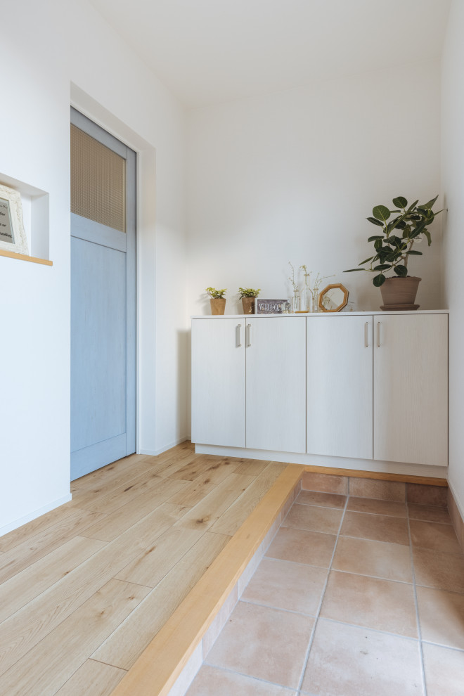 Ejemplo de hall escandinavo de tamaño medio con paredes blancas, suelo de madera clara, puerta simple, puerta de madera clara, suelo beige, papel pintado y papel pintado