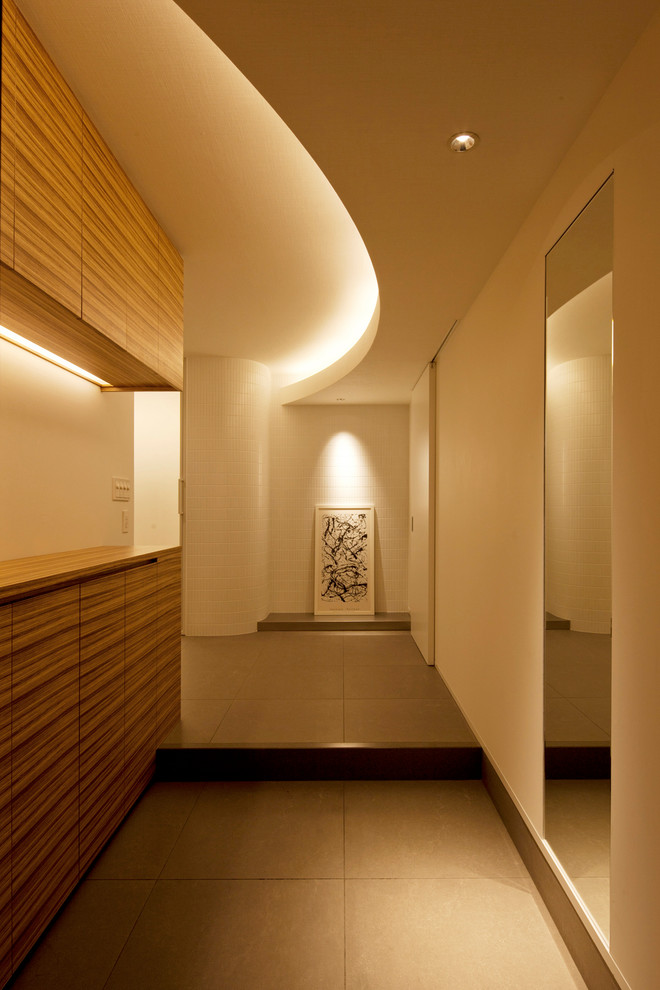 Large modern hallway in Other with white walls, ceramic flooring and grey floors.