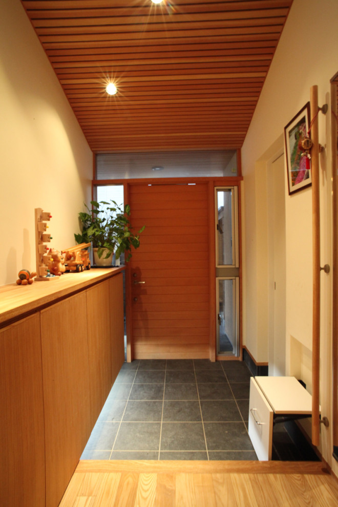 Mittelgroße Asiatische Haustür mit weißer Wandfarbe, Porzellan-Bodenfliesen, Einzeltür, hellbrauner Holzhaustür, grauem Boden und Holzdecke in Sonstige