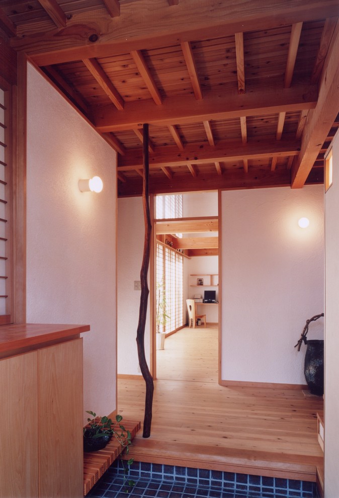 他の地域にある中くらいなラスティックスタイルのおしゃれな玄関 (白い壁、無垢フローリング、木目調のドア、ベージュの床) の写真