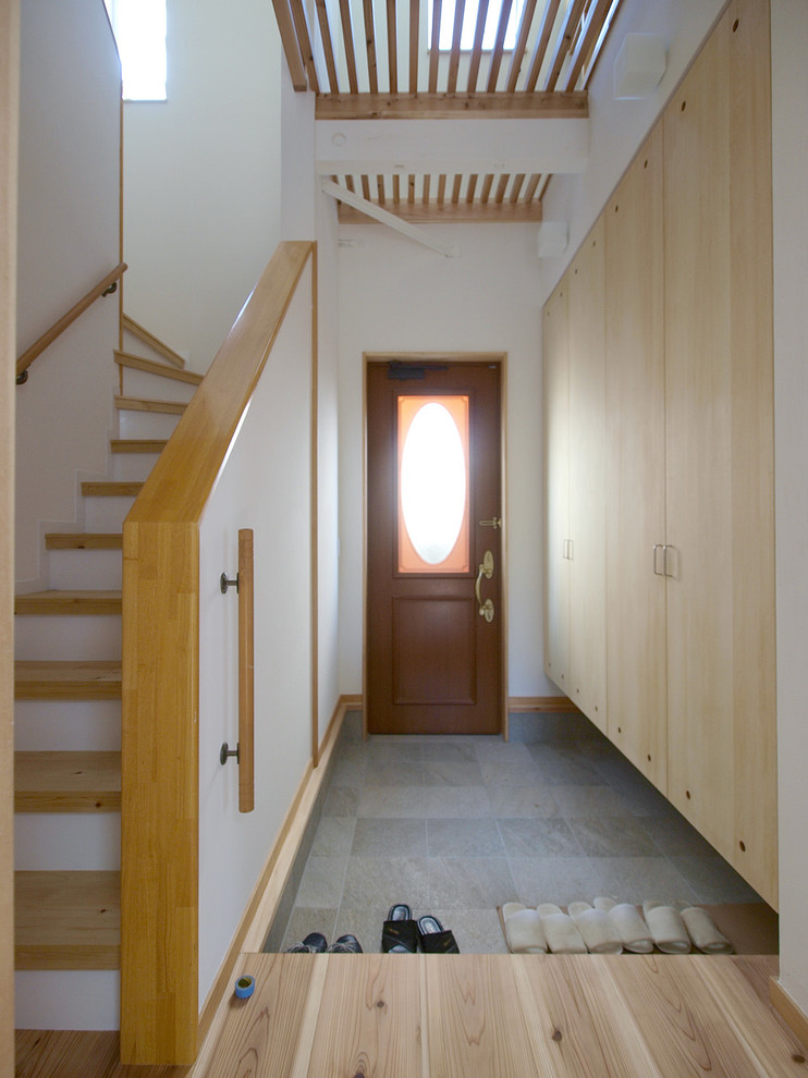 他の地域にある北欧スタイルのおしゃれな玄関 (白い壁、磁器タイルの床、グレーの床) の写真