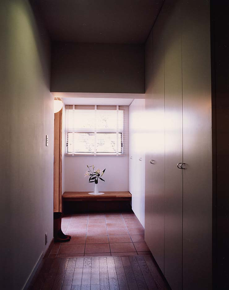 Foto di un corridoio moderno di medie dimensioni con pareti bianche, pavimento in terracotta, una porta singola, una porta in legno bruno, pavimento rosso, soffitto in perlinato e pareti in perlinato