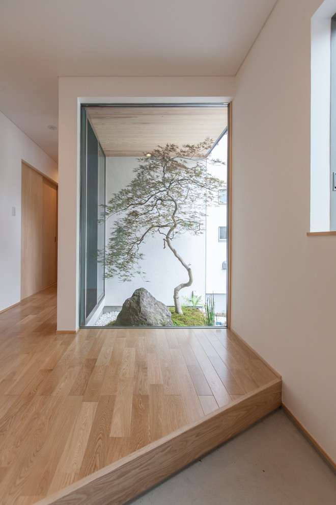Inspiration för en funkis entré, med vita väggar, en enkeldörr, mellanmörk trädörr och grått golv