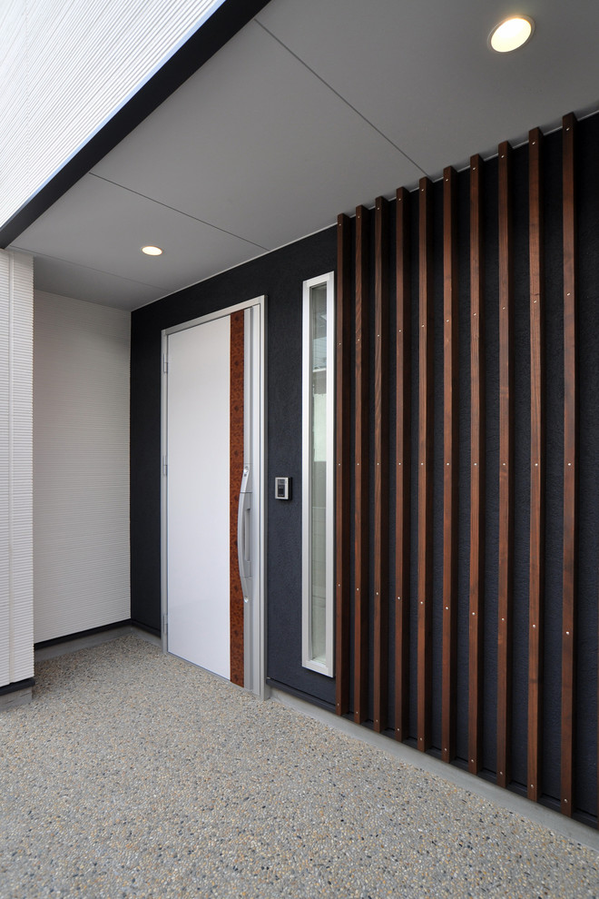 Ispirazione per un ingresso o corridoio moderno con pareti nere, pavimento alla veneziana, una porta singola, una porta bianca e pavimento grigio