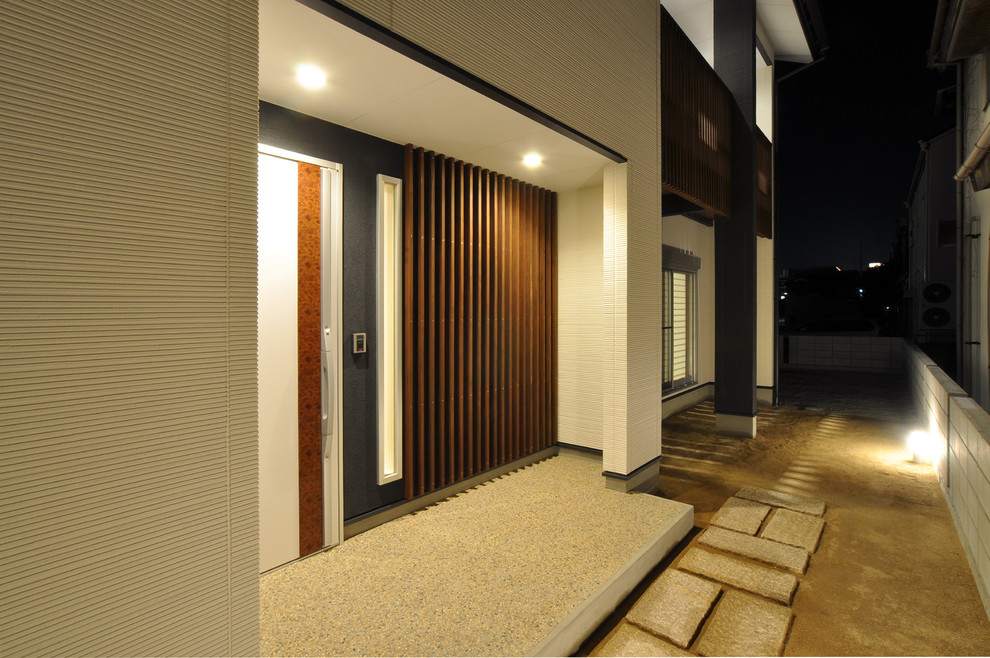 Cette photo montre une entrée moderne avec un mur blanc, un sol en terrazzo, une porte simple et une porte blanche.